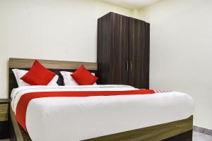 a bedroom with a large bed with red pillows at Flagship S&h Residency in Khandagiri