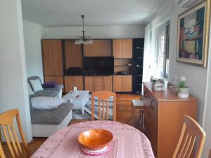 a living room with a table and a kitchen at Apartman Majda in Lepoglava