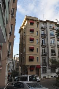 a tall building with red balconies in a city at Hotel Taksim Home in Istanbul