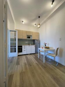 a kitchen with a white table and a table and chairs at Neighbor of Gellért Spa by NW in Budapest +12 photos