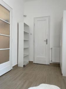 ein leeres Zimmer mit einer weißen Tür und Regalen in der Unterkunft Neighbor of Gellért Spa by NW in Budapest