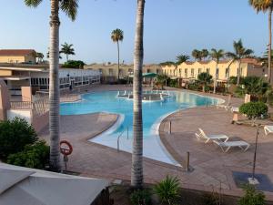 a large swimming pool with palm trees in a resort at Bungalow Green Oasis 1010 in Maspalomas