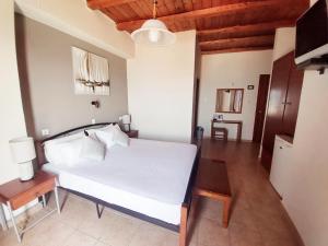 a bedroom with a white bed and a wooden ceiling at Agia Roumeli Hotel in Agia Roumeli