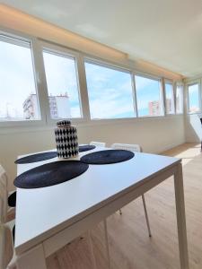 a white table in a room with windows at Aljarafe Central Square - by Pro Apartments in San Juan de Aznalfarache