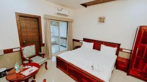 1 dormitorio con 1 cama, 1 mesa y 1 silla en Hotel Tirth by Sonu's, en Ujjain