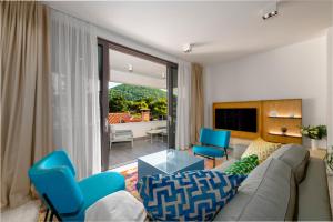 ein Wohnzimmer mit einem Sofa und zwei blauen Stühlen in der Unterkunft Luxury Apartments Mazza - Veronica in Dubrovnik