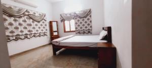 Cama pequeña en habitación con ventana en Shri Sai Baba Homestay - EB Colony - Trichy en Tiruchchirāppalli