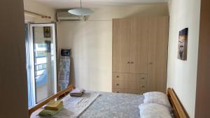 a bedroom with a bed and a closet and a window at Anxhelo's Apartment in Shëngjin