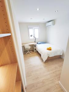 a small bedroom with a bed and a desk at Aljarafe Central Square - by Pro Apartments in San Juan de Aznalfarache