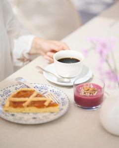 una mesa con una taza de café y un plato de comida en Hotel Al Maso, en Riva del Garda