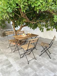 a wooden table and chairs under a tree at Casa Rural Puebla Deluxe in Puebla de Alcocer