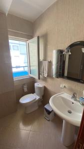 Łazienka z białą toaletą i umywalką w obiekcie Anxhelo's Apartment w mieście Shëngjin