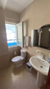 a bathroom with a white toilet and a sink at Anxhelo's Apartment in Shëngjin +5 photos