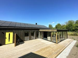 una casa con terraza y techo negro en Very nice cottage near Borgholm, en Borgholm