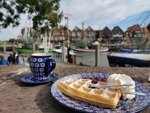 a plate of waffles with ice cream and a cup of coffee at Ferienhaus Oll Smee 9 Huus EEN mit Terrasse, Grill und kleinem Garten in Werdum