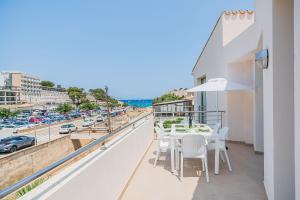 Un balcón con mesa y sillas y vista a una ciudad. en Molins 6, en Cala de Sant Vicent