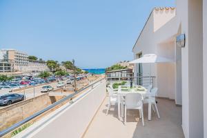 a balcony with a table and chairs and a view of a city at Molins 6 in Cala de Sant Vicenc