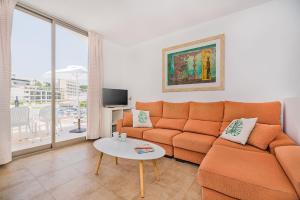 sala de estar con sofá naranja y mesa en Molins 6, en Cala de Sant Vicent