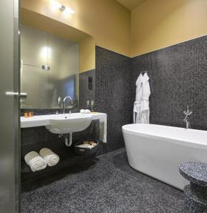 a bathroom with a tub and a sink and a bath tub at Verno House in Budapest