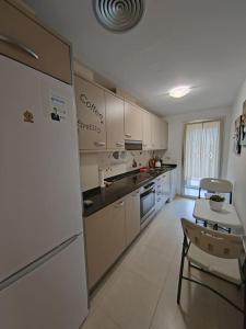 a kitchen with a refrigerator and a table and chairs at Magnifico Paradis Village in Salou