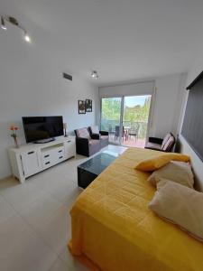 a bedroom with a large yellow bed and a living room at Magnifico Paradis Village in Salou