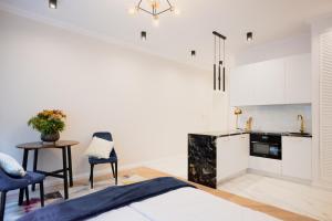 a bedroom with a bed and a table and a kitchen at LuxuryApartamentsIjordC in Katowice