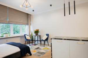 a bedroom with a bed and a table and chairs at LuxuryApartamentsIjordC in Katowice