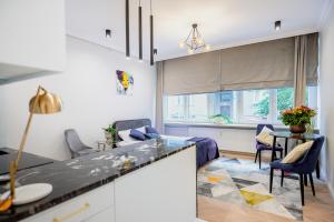 a kitchen and living room with a table and chairs at LuxuryApartamentsIjordC in Katowice