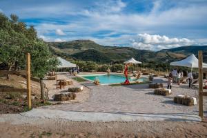 a pool at a resort with people standing around it at Agriturismo Sa Tanca Noa in Tergu
