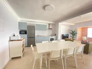 a kitchen and dining room with a white table and chairs at Gáldar G.C.Frontón in Gáldar