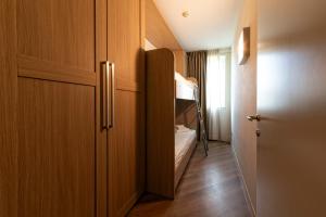 Mały pokój z szafą i łóżkiem piętrowym w obiekcie Lake Garda Resort w mieście Moniga