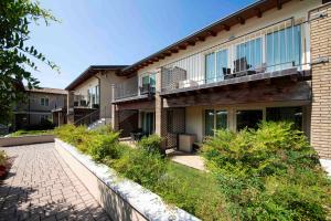 a building with a walkway in front of it at Lake Garda Resort in Moniga