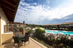 un balcone con vista sulla piscina di un resort di Lake Garda Resort a Moniga