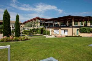 a large building with a lawn in front of it at Lake Garda Resort in Moniga