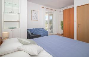 a white bedroom with a large bed and a window at Apartmani Krmek in Mlini