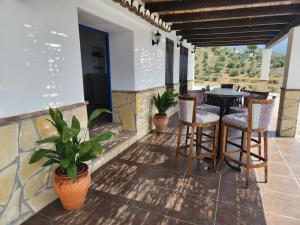 een patio met een tafel, stoelen en planten bij VILLA GABRIEL in Canillas de Albaida