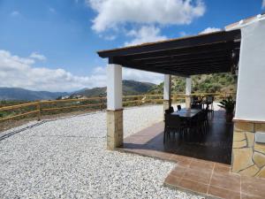 a pavilion with a table and chairs under a roof at VILLA GABRIEL in Canillas de Albaida