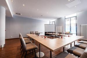 une salle de conférence avec une grande table et des chaises en bois dans l'établissement Premier Inn Dresden City Zentrum, à Dresde