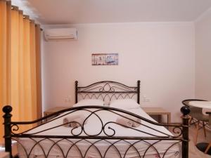 a bedroom with a black bed with white sheets at Vironas Hotel in Himare