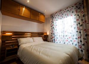 1 dormitorio con cama blanca y ventana en Apartamento Granados, en Granada