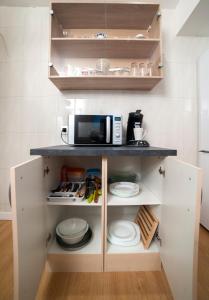 a kitchen with white cabinets and a microwave at Apartamento Granados in Granada +13 photos