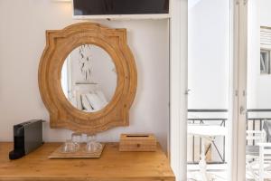 a mirror sitting on top of a wooden table at Parosquare Central Suites in Parikia
