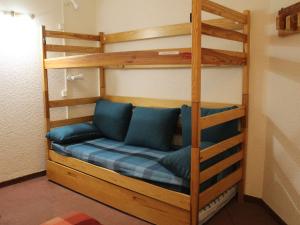 a bunk bed with blue pillows in a room at Appartement Vars, 1 pièce, 4 personnes - FR-1-330B-121 in Vars