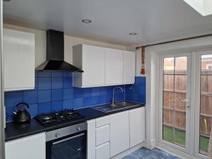 a kitchen with white cabinets and a stove at Studio Flat with kitchen and toilet included in Dagenham