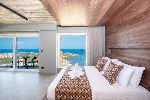 a bedroom with a bed with a view of the ocean at Salini Suites in Żebbuġ