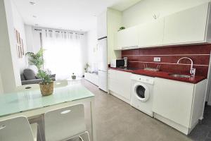 a kitchen with a sink and a washing machine at Apartamento Bajo 1 Marjal playa centro de Guardamar in Guardamar del Segura