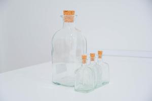 trois bouteilles en verre avec liège sur fond blanc dans l'établissement For You Rentals Cozy and charming 3-bedroom apartment in Madrid ASR18, à Madrid