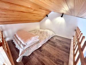 um pequeno quarto com uma cama e pisos em madeira em Charmant Studio 25 m² avec mezzanine et piscine em Tilh