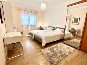 ein Schlafzimmer mit einem großen Bett und einem Spiegel in der Unterkunft Casa Cabo Avelar T4 - Mer in Peniche