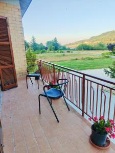 two chairs on a balcony with a view of a river at Affittacamere Sanja in San Ginesio